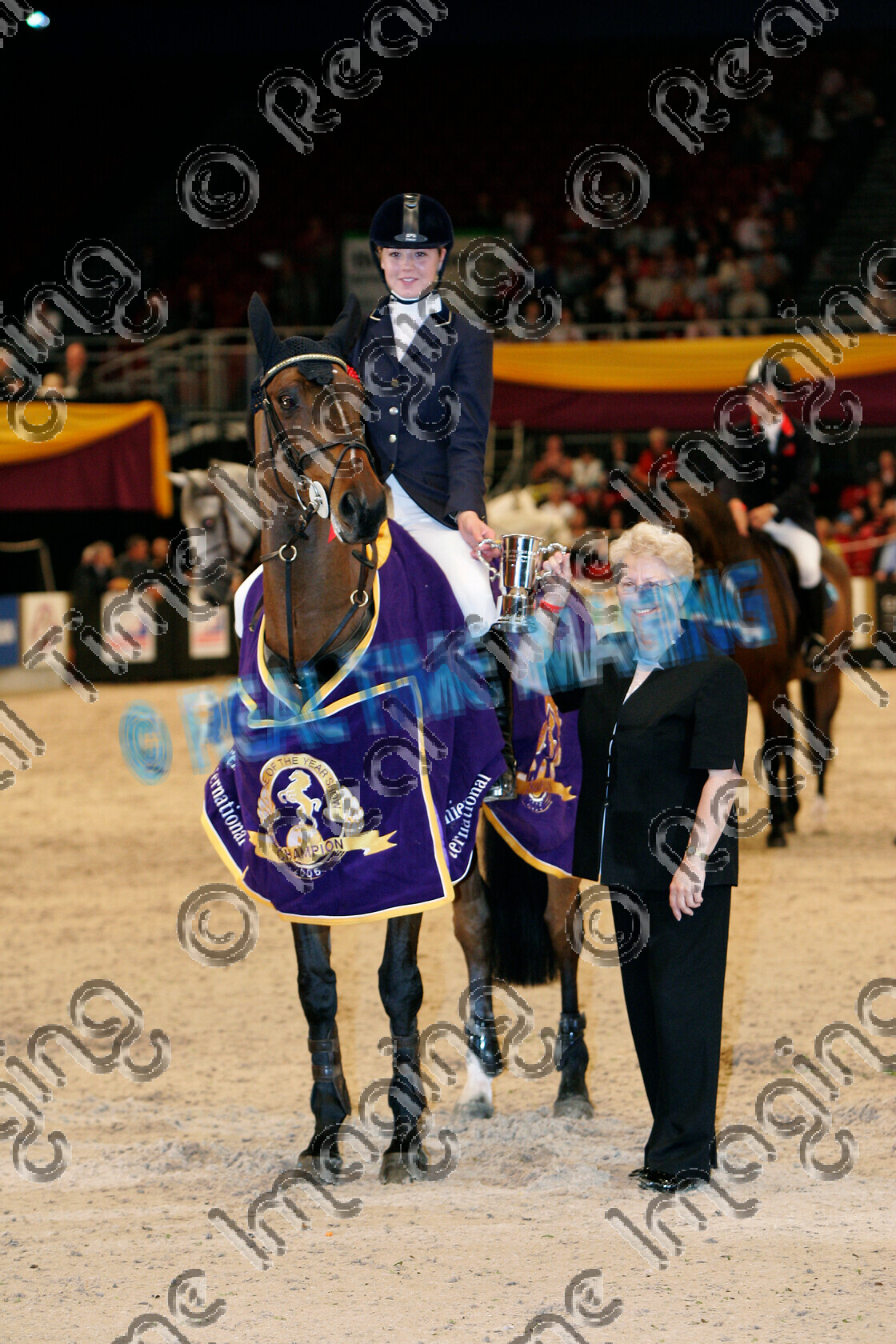 S05-64-13-002 
 HOYS 2005: The Young Riders Championship of Great Britain winner 
 Keywords: horse of the year show 2005 05 hoys wednesday 12 10 october 4 The Young Riders Championship of Great Britain winner 217 henri de here ellen whitaker showjumping showjumper standing presentation rug trophy rosette